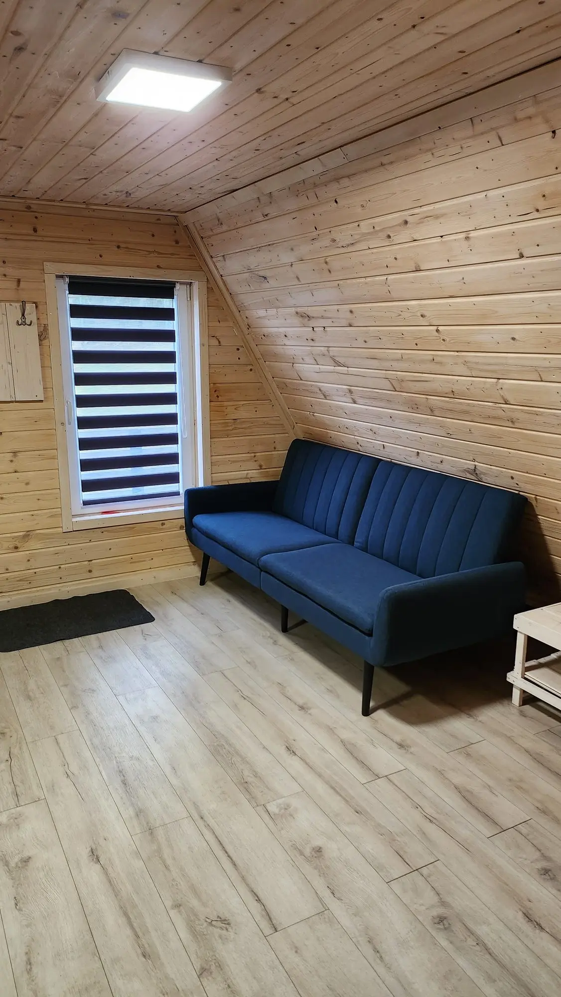 Kącik wypoczynkowy w domku: rozkładana sofa przy oknie