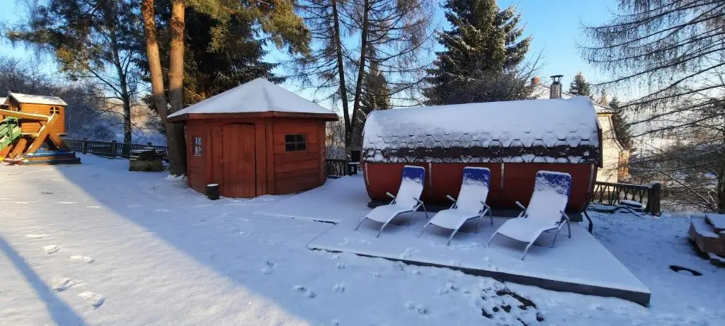 Sauna beczka i sauna drewniana na terenie ośrodka zimą